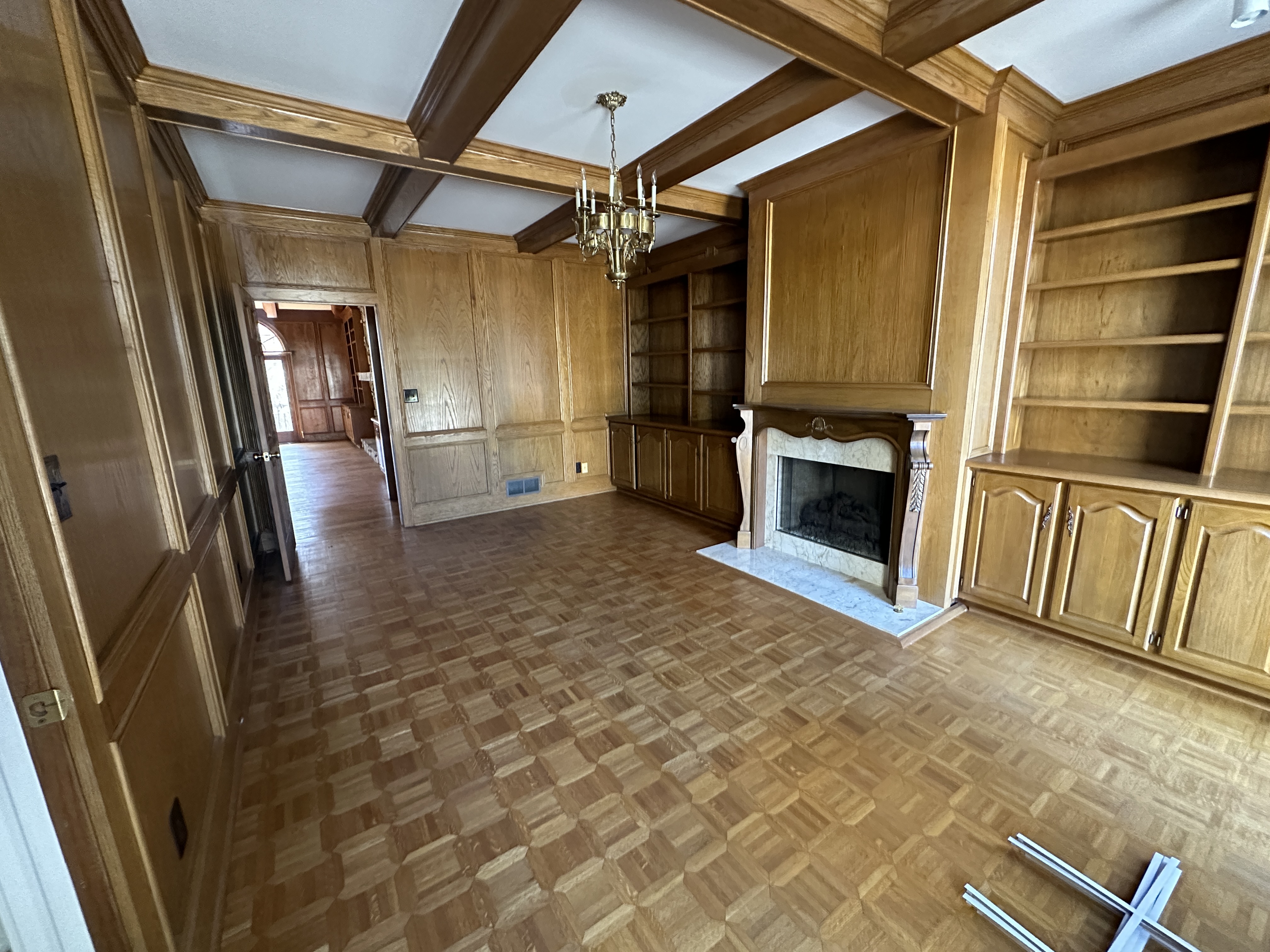 Living room before — wood paneling and parquet