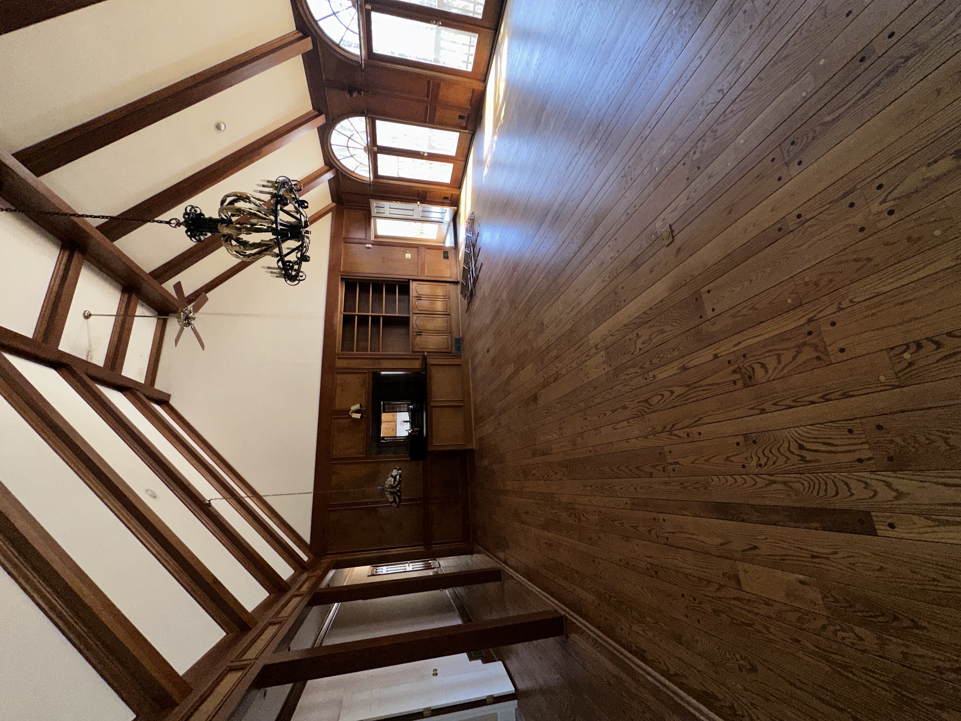 Great room before — wood paneling, built-in entertainment center