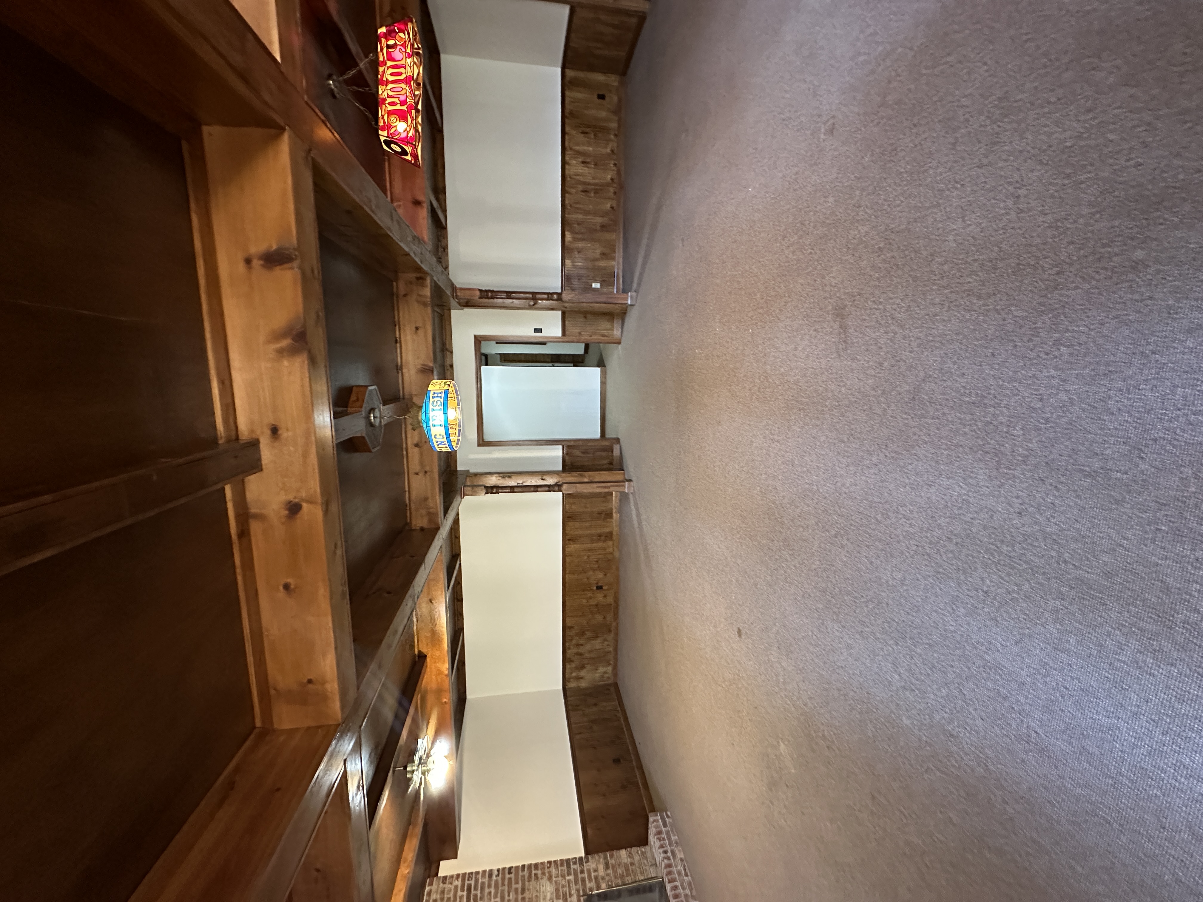 Room before — carpet, wood built-ins, exposed beams