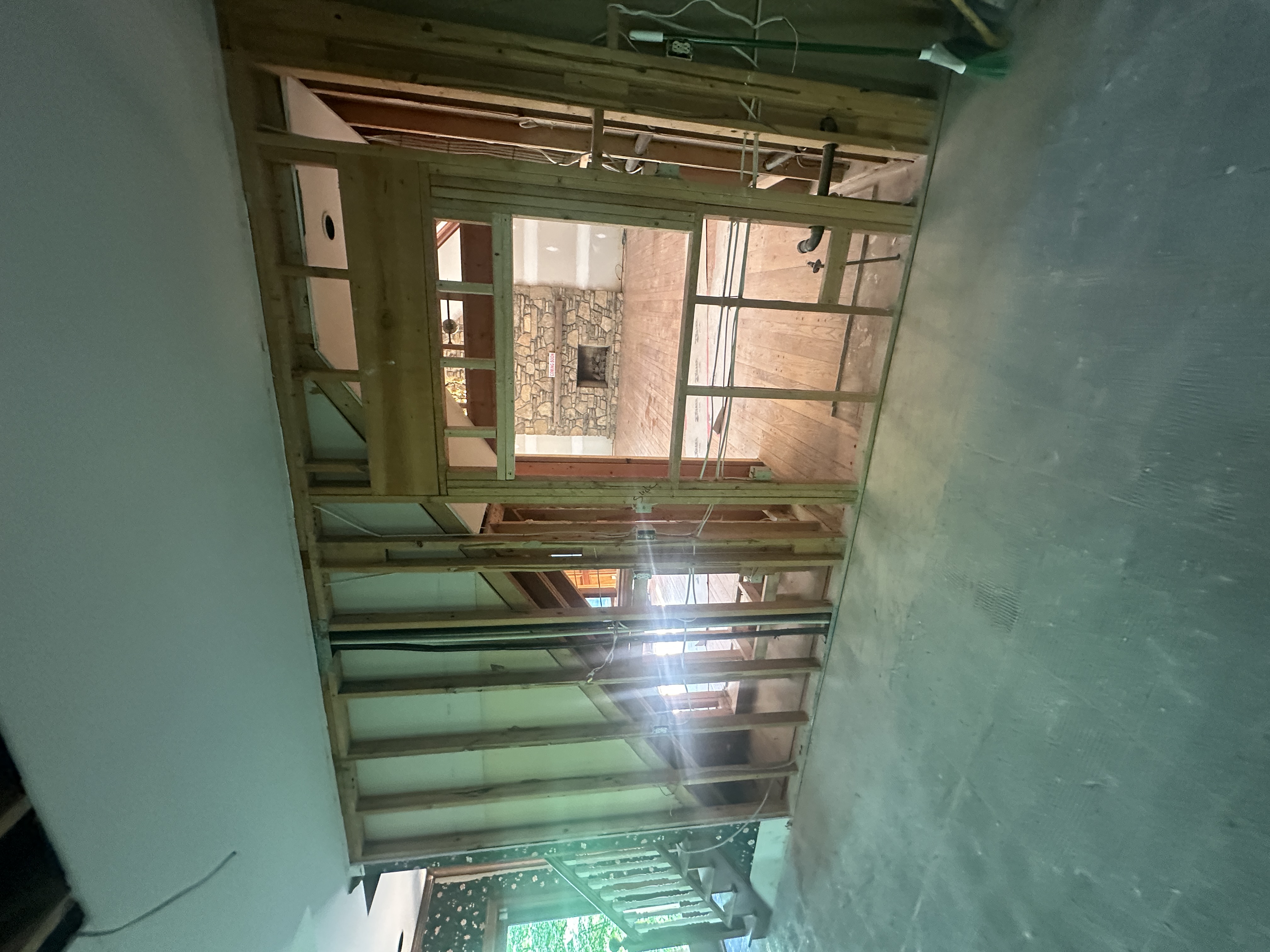 Room being gutted — exposed studs and framing