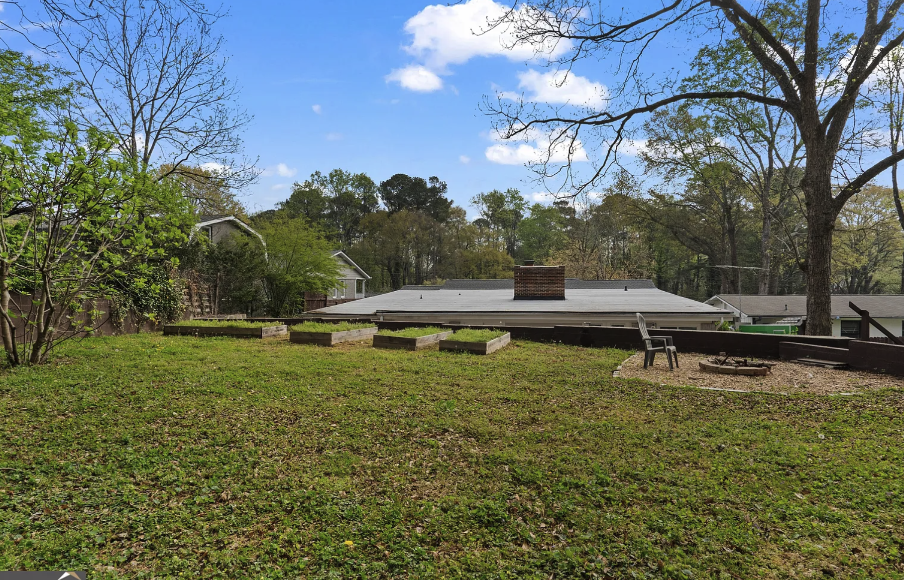 Backyard after — large deck, raised garden beds, green lawn