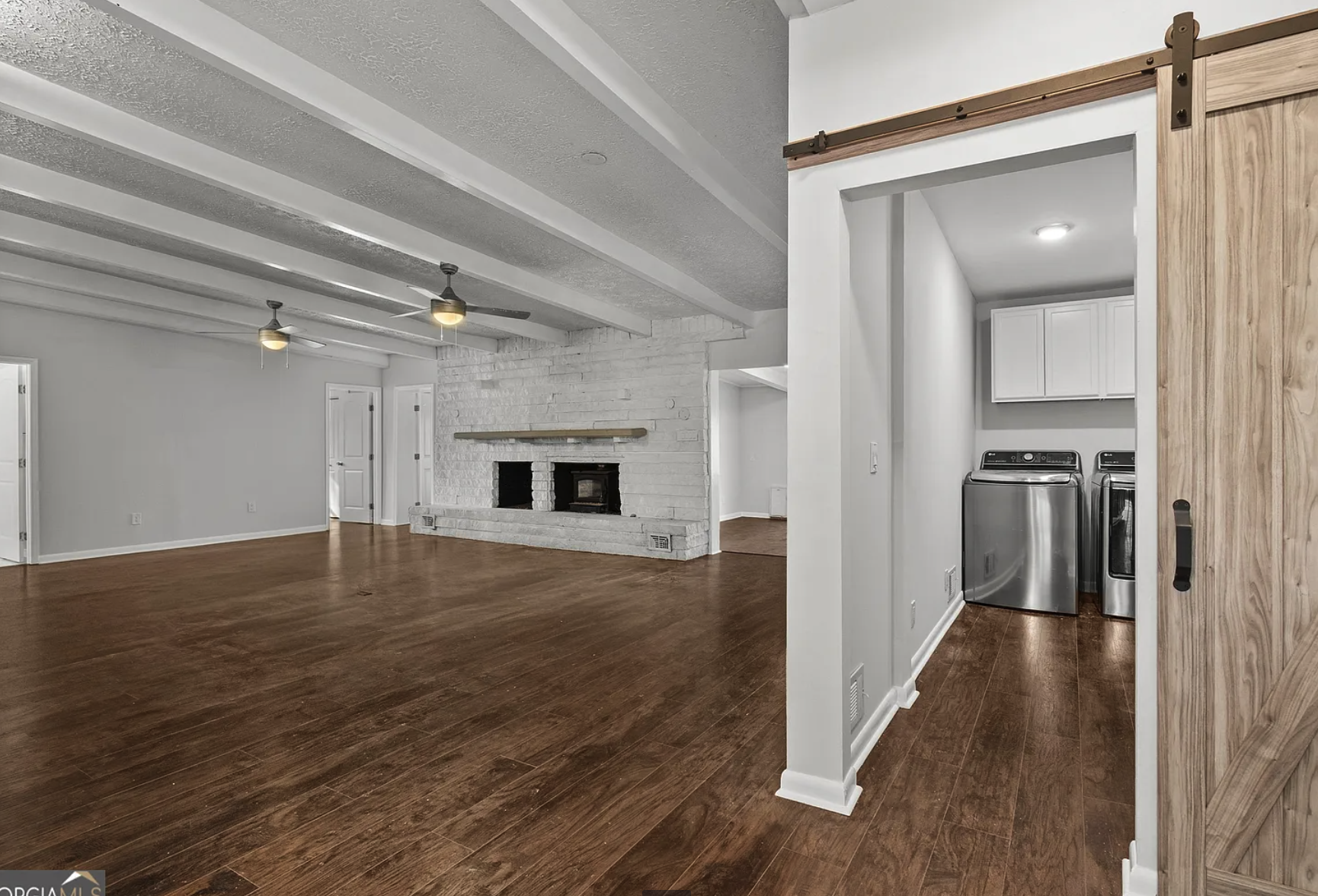 Great room with barn door to laundry, stainless washer/dryer