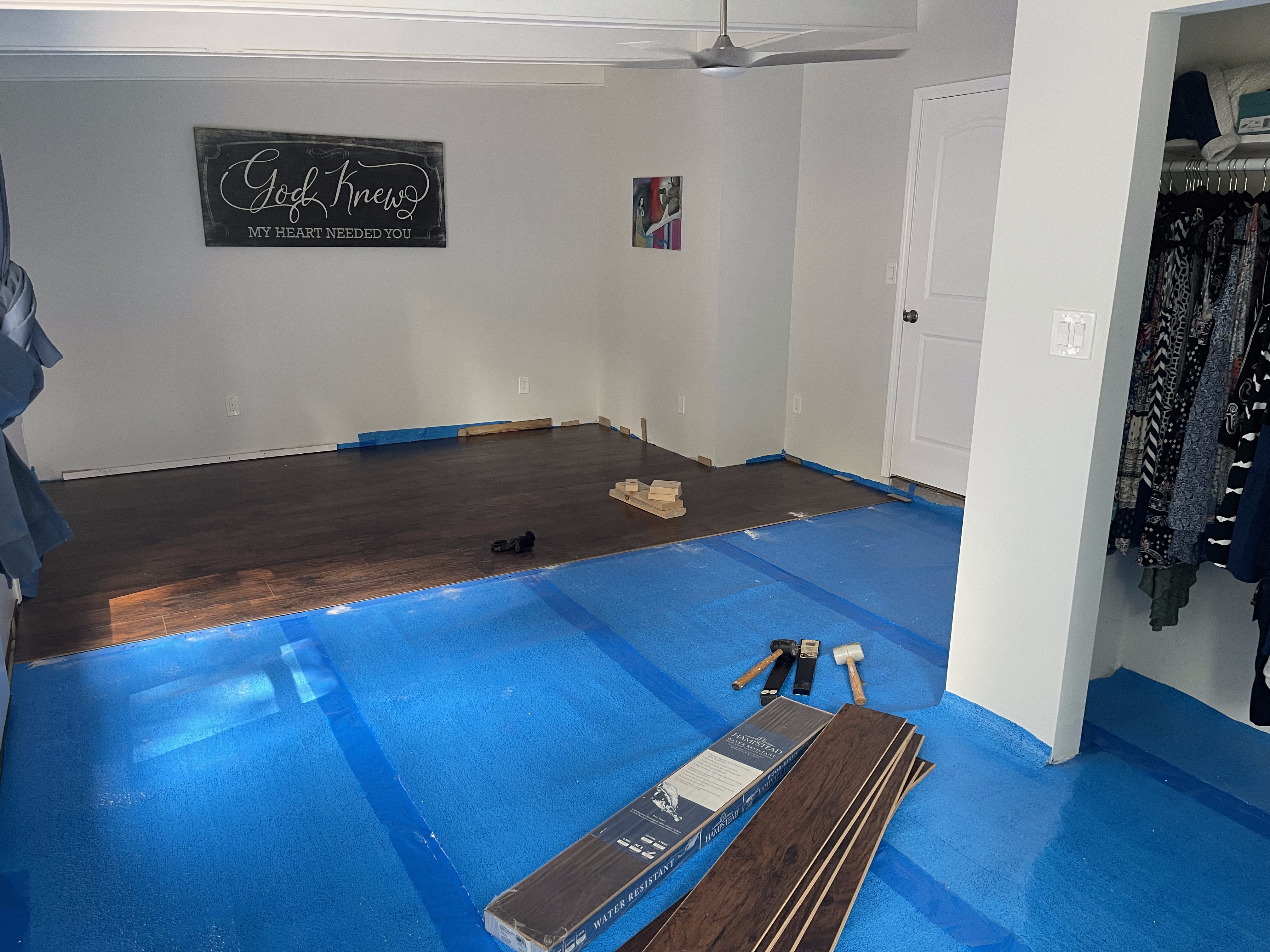 Hardwood flooring being installed over blue underlayment