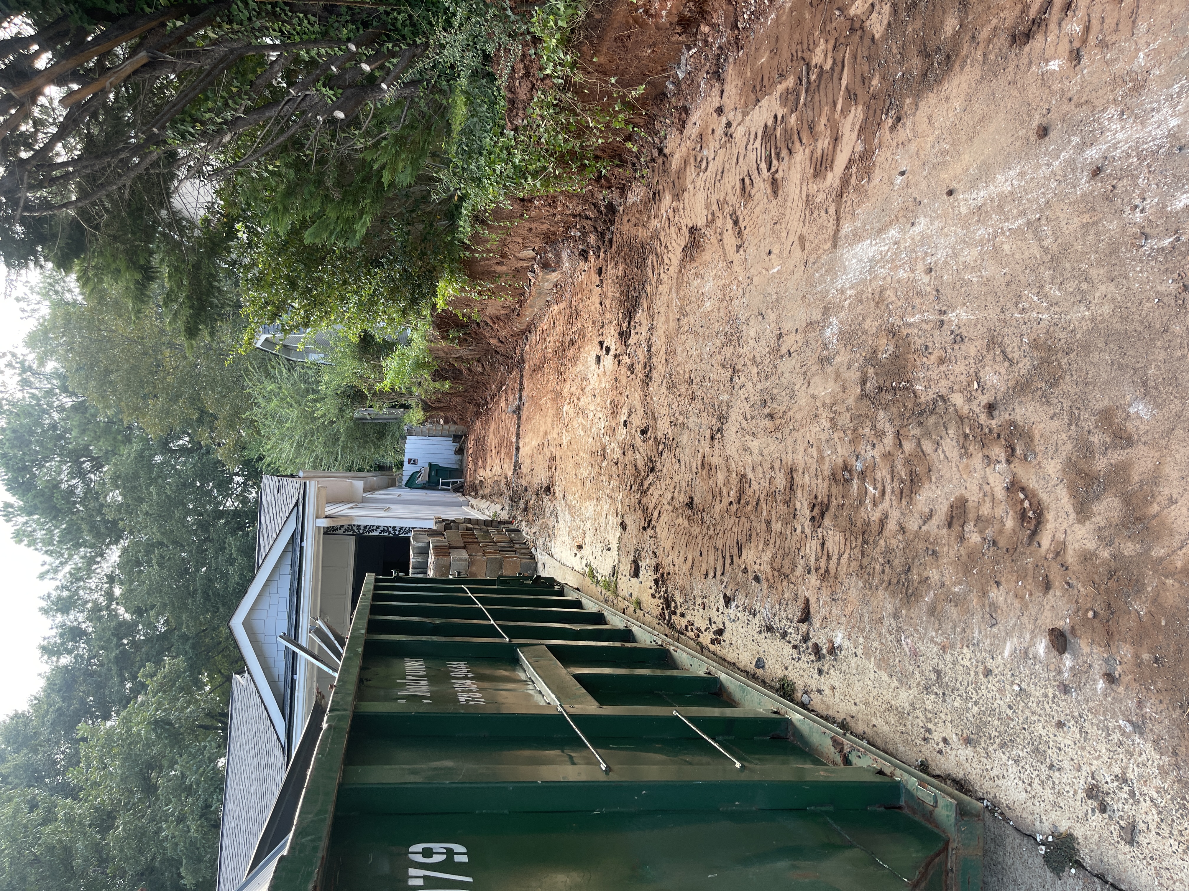 Exterior before — dumpsters, exposed dirt, construction