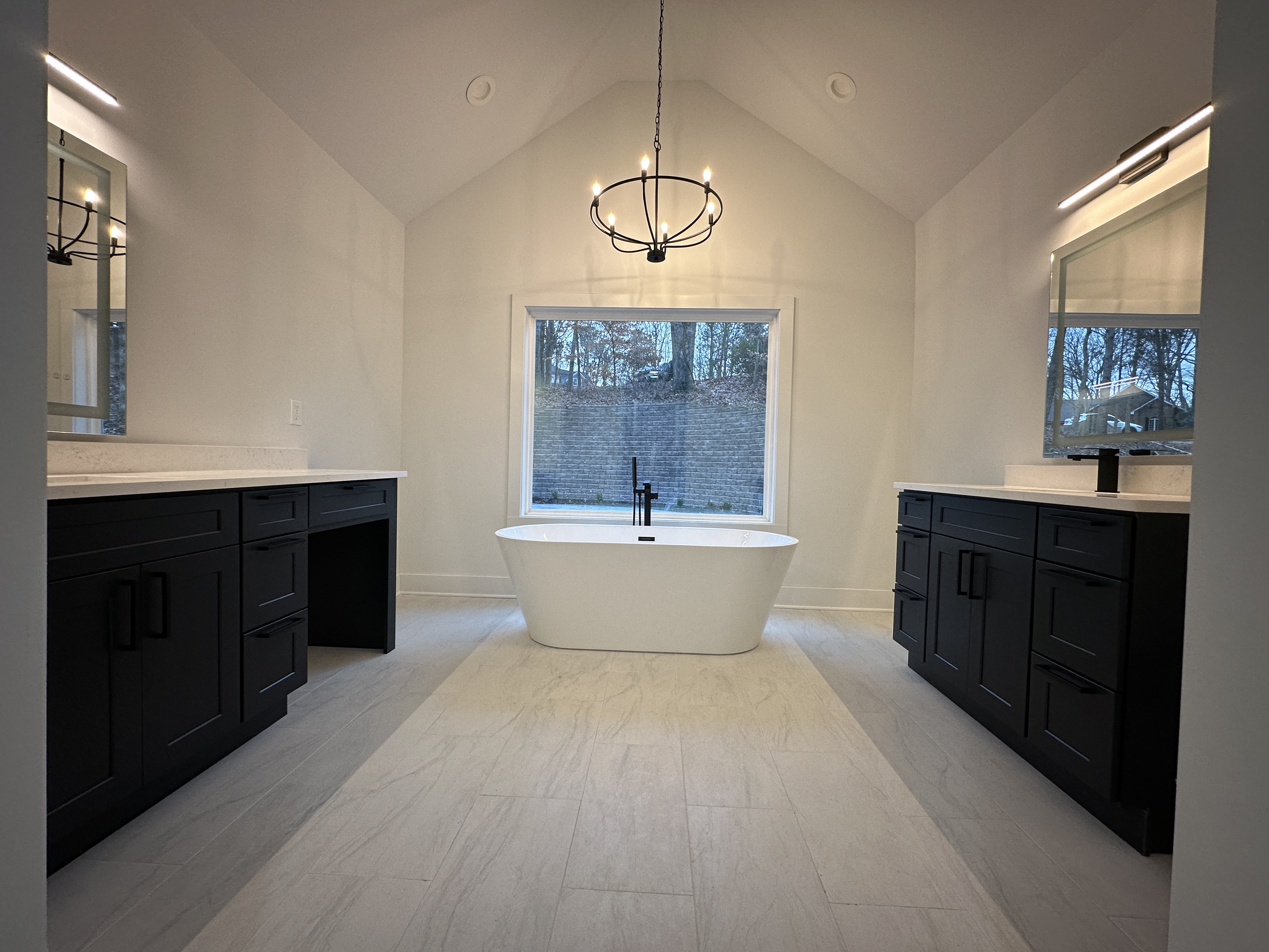 Primary bathroom — freestanding tub, dual dark vanities