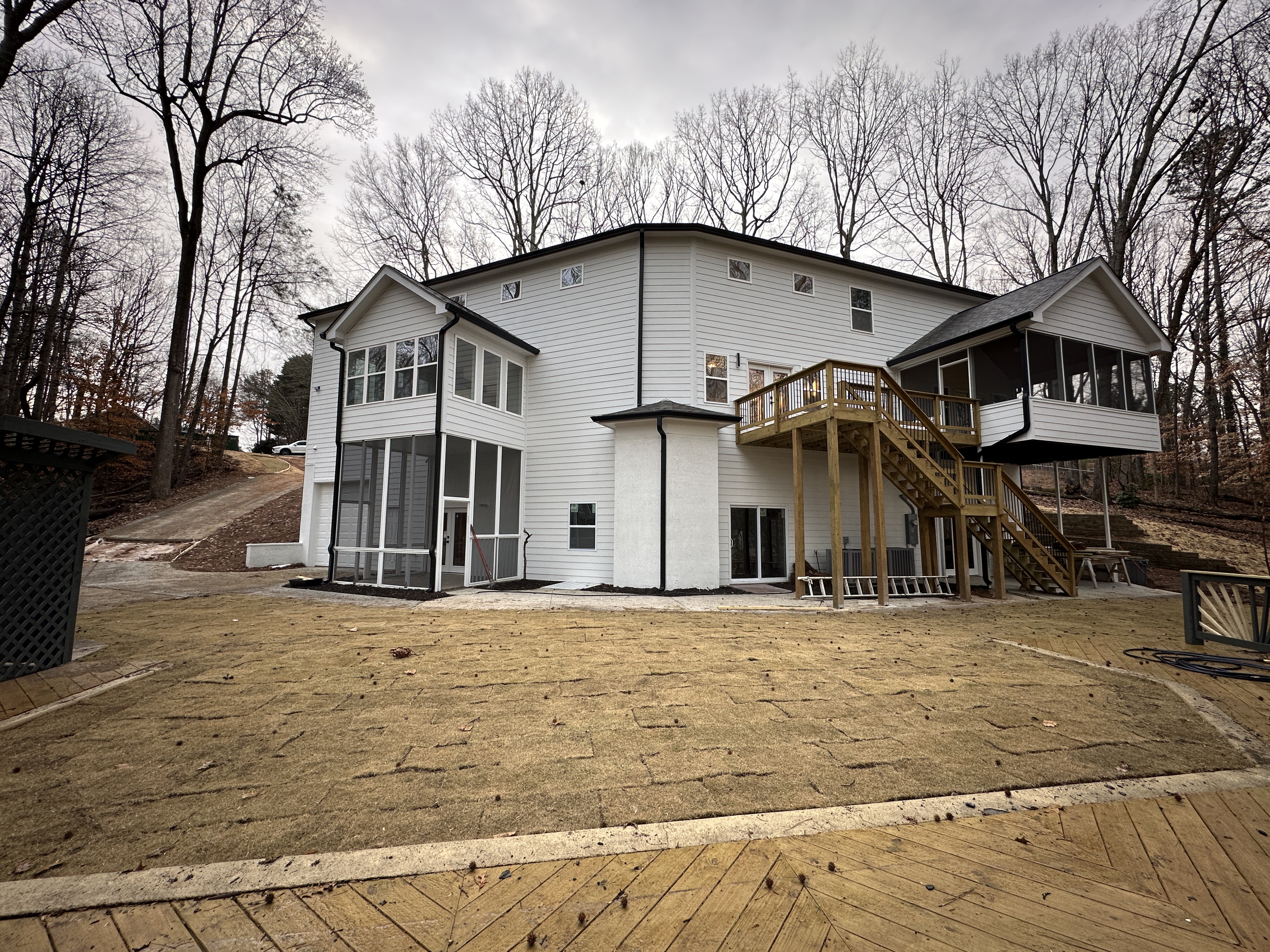 Rear exterior after — white siding, screened porches, deck
