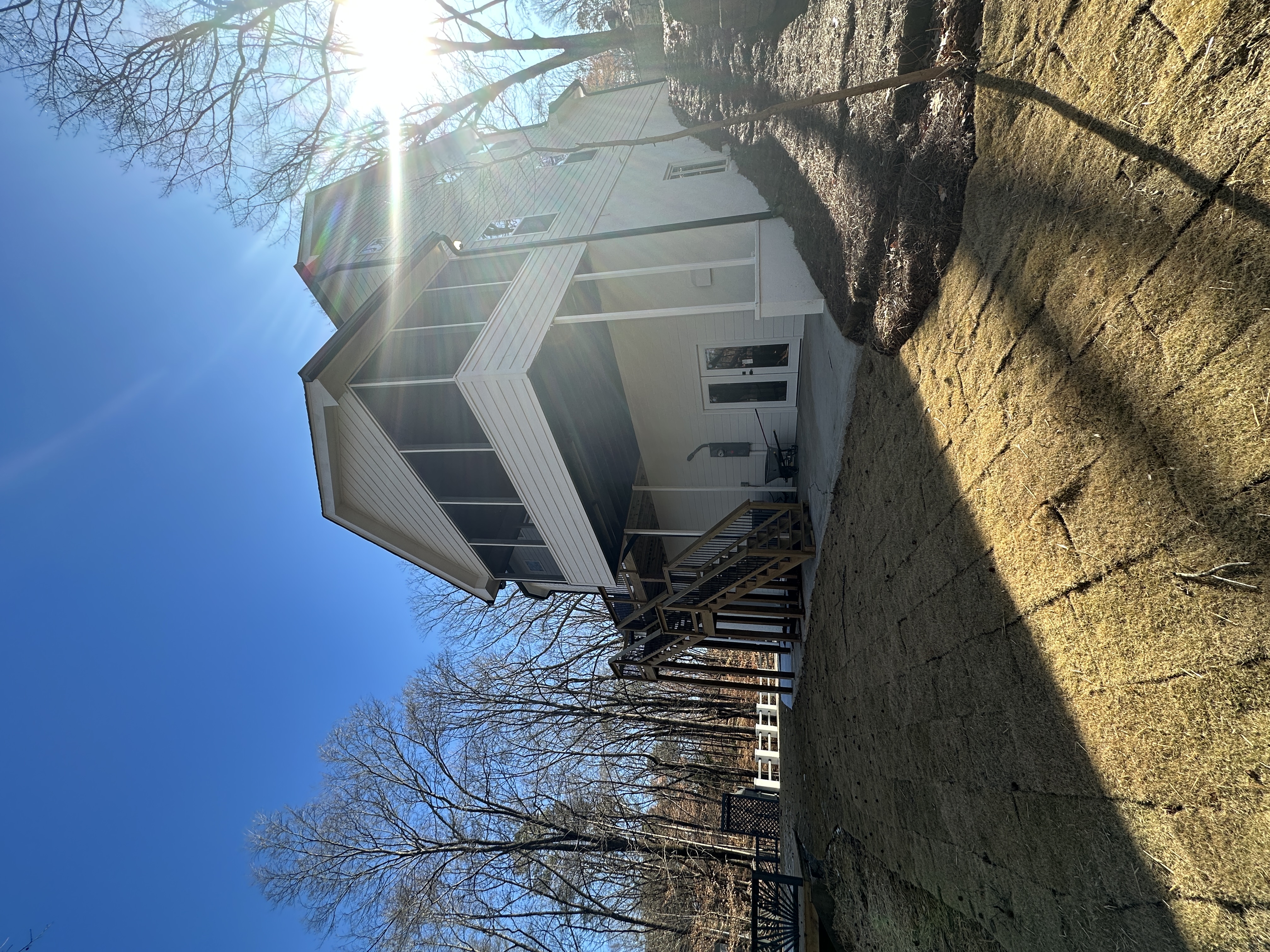 Rear exterior with sun flare, screened porch