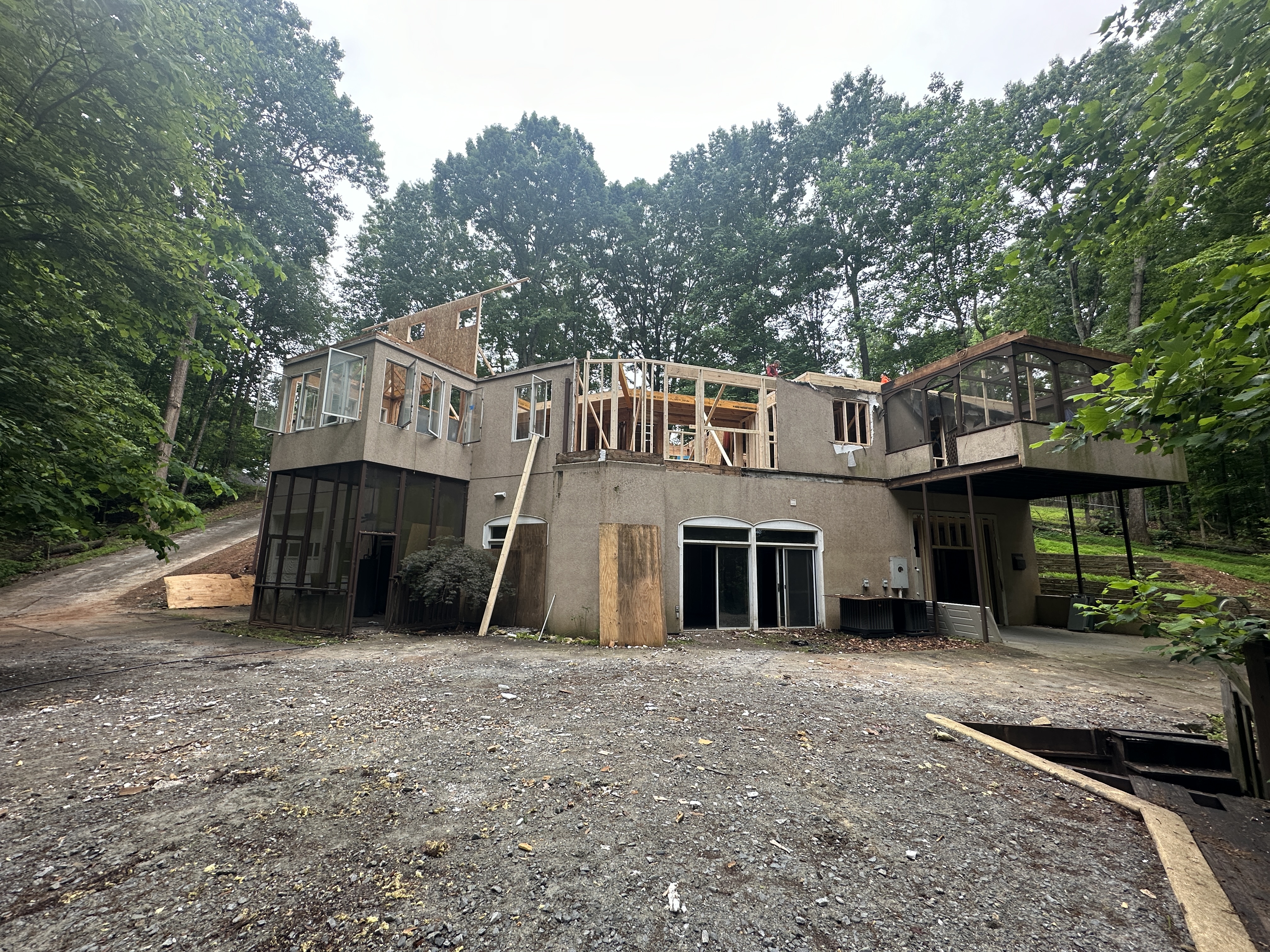 Rear exterior during demolition — stucco structure being torn apart